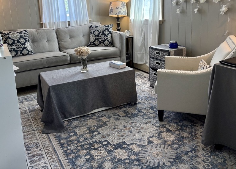 Calm therapy room with a sofa and armchair at The Anxiety and Agoraphobia Treatment Center